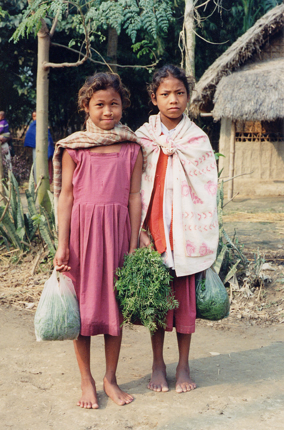 Two Girls On Dirt Road Holding Bags / Nepal / Taru